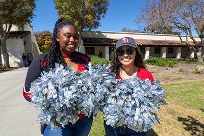 Two transfer students holding silver pom-poms