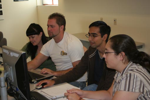 Rich Alegre, Alyssa Bremner, Josefina Flores, Israel Rodriguez looking at a computer