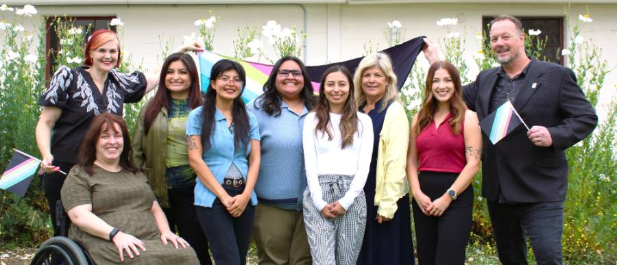 Photo of the 9 DASS staff members and the disability pride flag