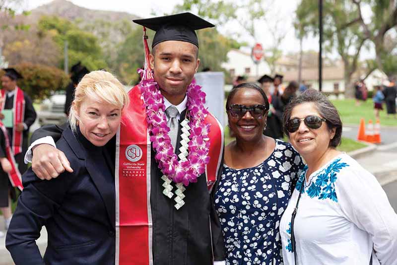 A graduating senior celebrates with family after the 2018 commencement