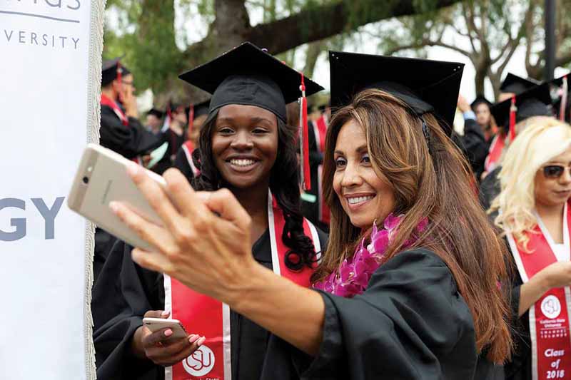 Two graduates commemorate the event with a selfie shot.