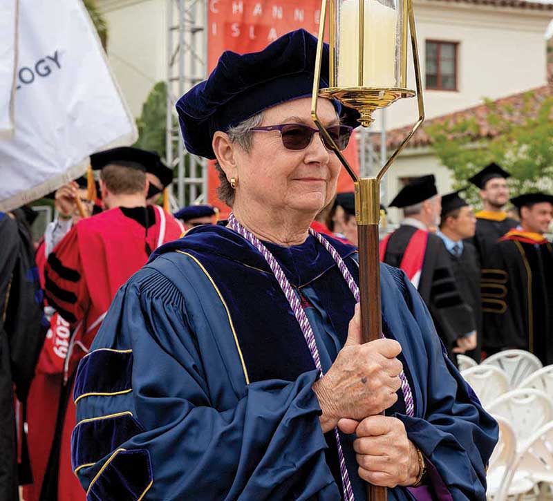 Associate Professor of Health Science Carol Mack carries the Light of Learning