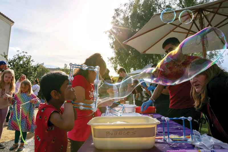 A STEAM Carnival attendee enjoys the physics of a square bubble blowing device.